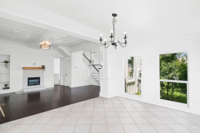 unfurnished living room with beamed ceiling, light hardwood / wood-style flooring, a chandelier, and plenty of natural light