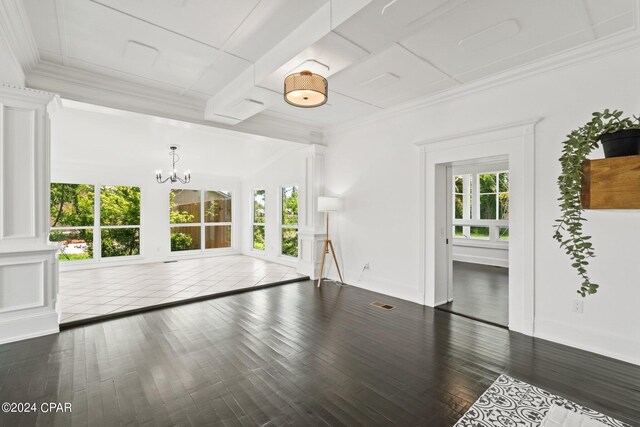 unfurnished living room featuring a notable chandelier, dark hardwood / wood-style flooring, and a wealth of natural light