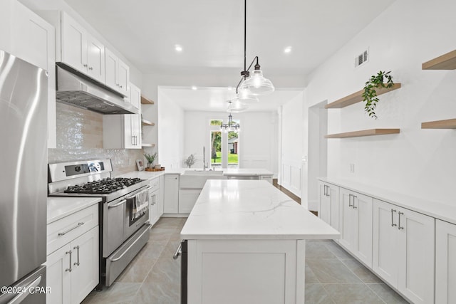 kitchen with light tile patterned flooring, tasteful backsplash, a kitchen island, stainless steel appliances, and sink