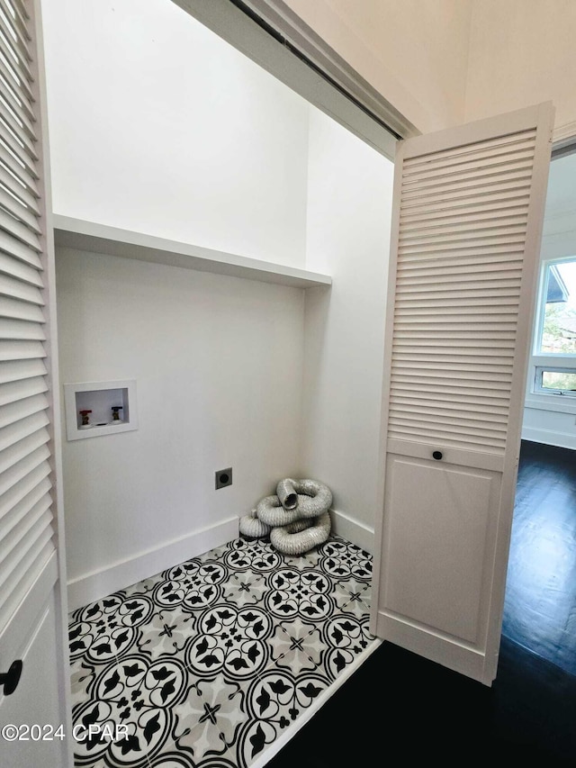 laundry area featuring dark tile patterned floors, hookup for an electric dryer, and hookup for a washing machine