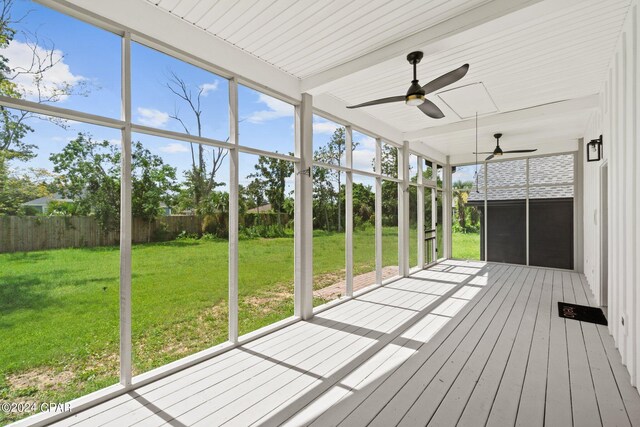 unfurnished sunroom featuring a healthy amount of sunlight and ceiling fan