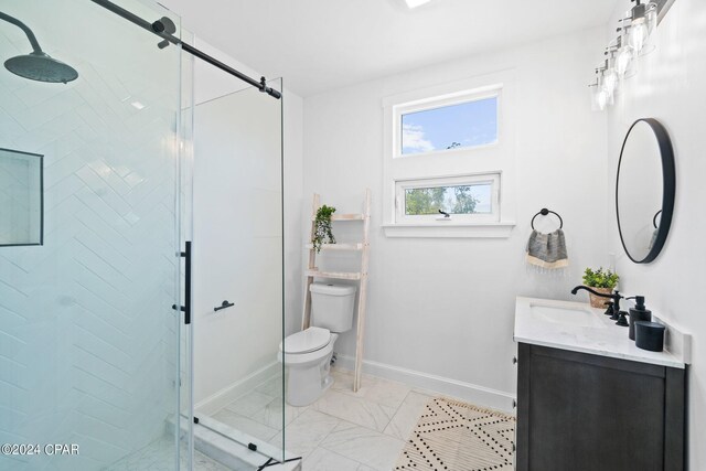 bathroom with a shower with shower door, vanity, tile patterned floors, and toilet