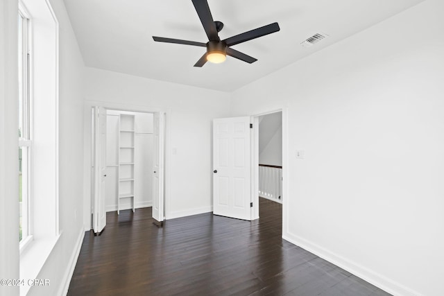 unfurnished bedroom with a closet, ceiling fan, and dark wood-type flooring