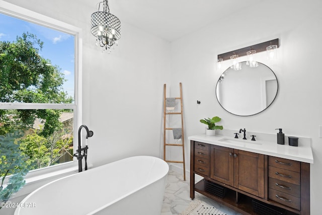 bathroom with vanity, an inviting chandelier, and a bathing tub