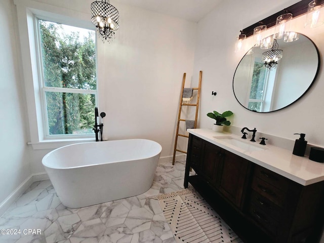 bathroom featuring tile patterned flooring, a washtub, vanity, and an inviting chandelier