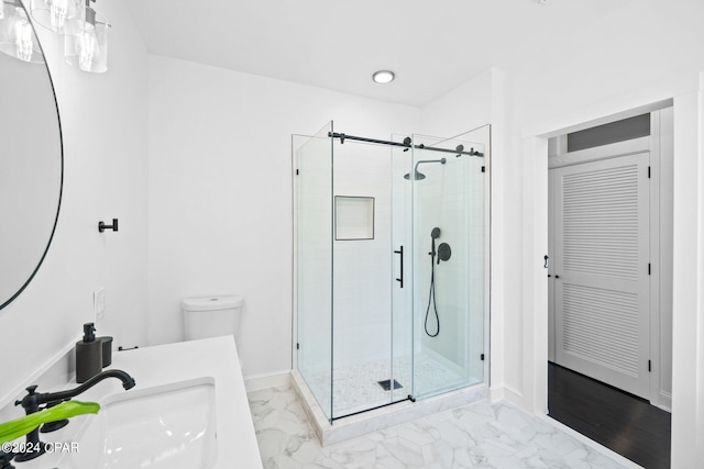 bathroom featuring a shower with shower door, vanity, toilet, and tile patterned floors