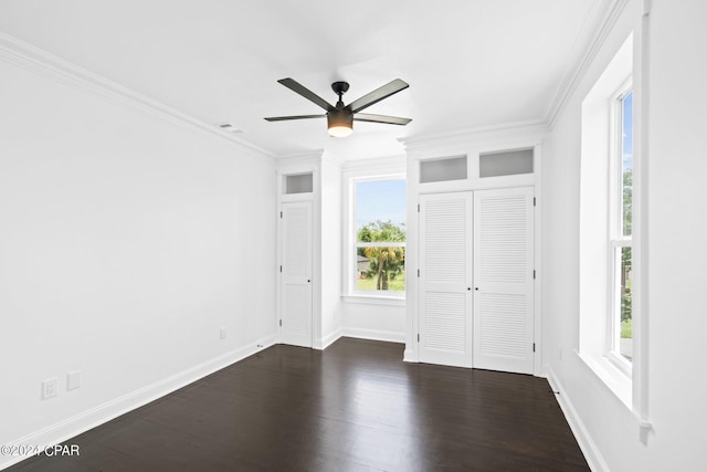 unfurnished bedroom featuring dark wood-type flooring, ornamental molding, and ceiling fan