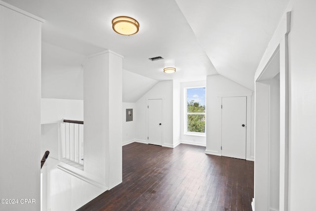 additional living space featuring electric panel, dark wood-type flooring, and vaulted ceiling