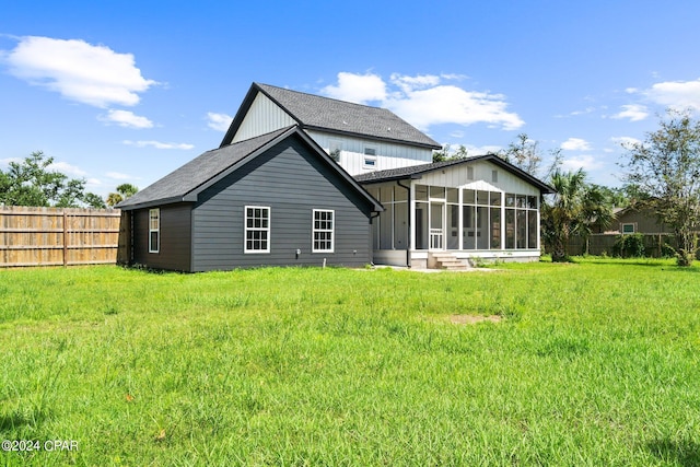 back of house with a yard and a sunroom