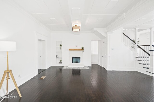 unfurnished living room with built in shelves, dark hardwood / wood-style flooring, and decorative columns