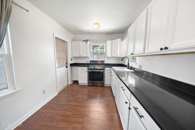 kitchen featuring sink, stainless steel range oven, dark hardwood / wood-style flooring, and white cabinets