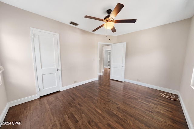 spare room with ceiling fan and dark wood-type flooring