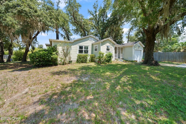 single story home featuring a garage and a front yard