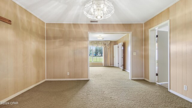 corridor with carpet, wooden walls, and an inviting chandelier