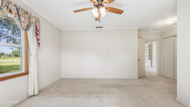 carpeted spare room featuring ceiling fan and ornamental molding