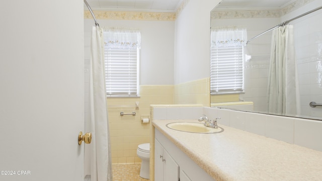 bathroom with vanity, tile patterned flooring, toilet, ornamental molding, and tile walls