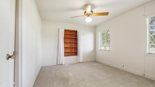 carpeted spare room with ceiling fan