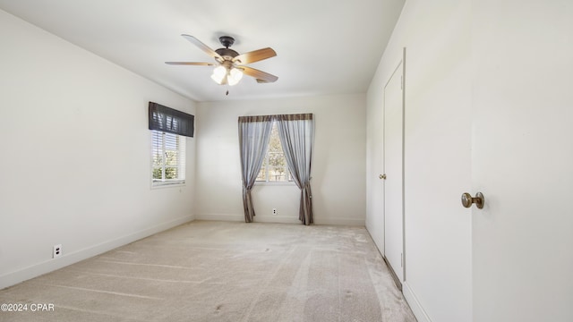 unfurnished bedroom with ceiling fan and light colored carpet