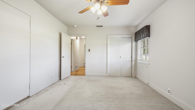 unfurnished bedroom featuring ceiling fan and light colored carpet