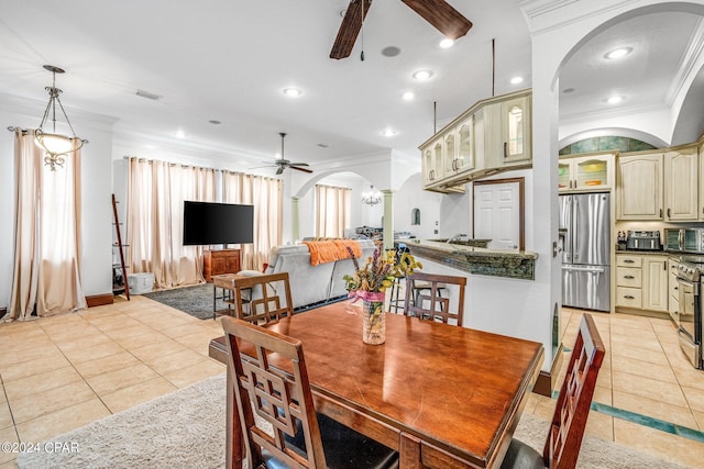 tiled dining room with crown molding, sink, and ceiling fan