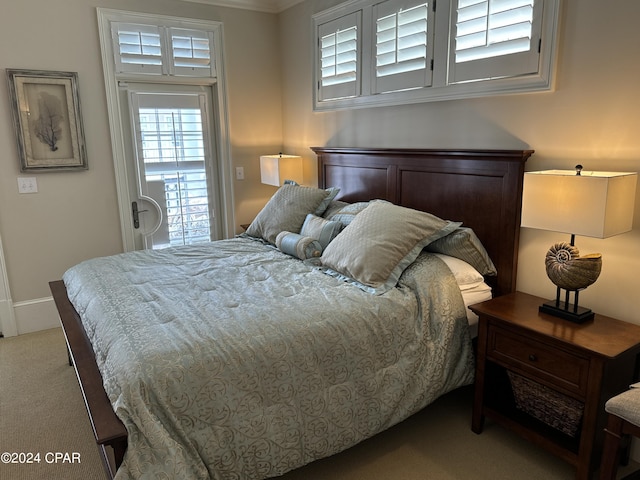 bedroom with ornamental molding and light colored carpet