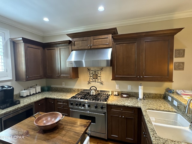 kitchen featuring light stone counters, sink, and stainless steel range