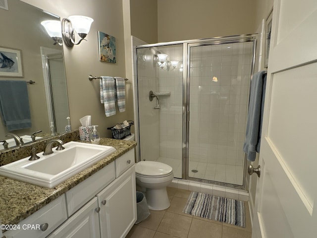 bathroom featuring vanity, toilet, an enclosed shower, and tile patterned flooring