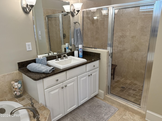 bathroom with an enclosed shower, vanity, and tile patterned floors