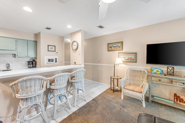 kitchen with ceiling fan, decorative backsplash, and light tile patterned floors