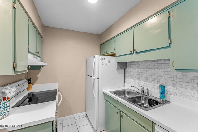 kitchen featuring sink, green cabinetry, backsplash, and light tile patterned floors