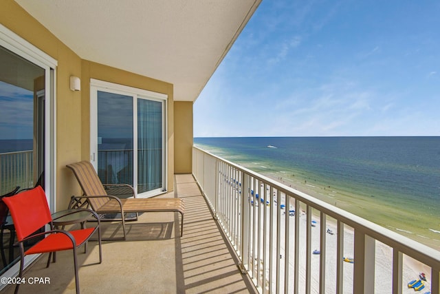 balcony featuring a view of the beach and a water view