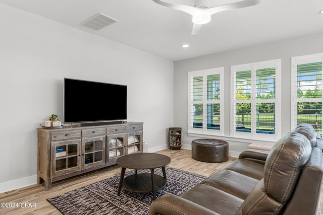 living room with ceiling fan, wood-type flooring, and a wealth of natural light