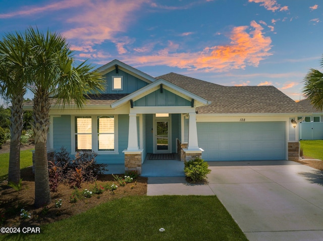 craftsman-style house with a porch, a garage, and a yard