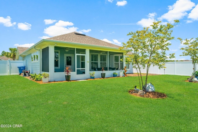 rear view of house with a yard and a sunroom