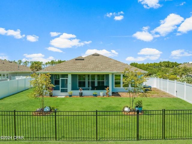 rear view of house featuring a sunroom and a yard