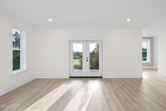 empty room featuring french doors and light wood-type flooring