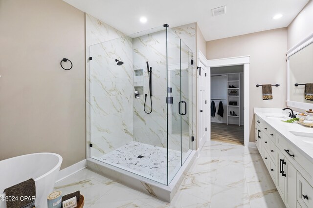 full bathroom with marble finish floor, a marble finish shower, a walk in closet, and baseboards