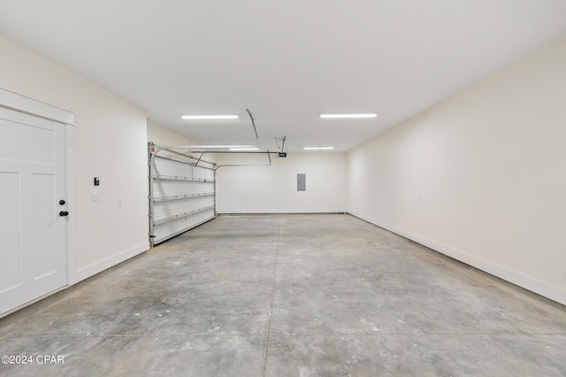 garage featuring electric panel and baseboards