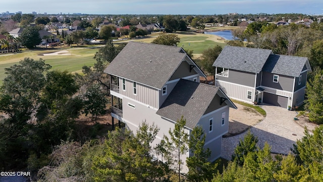 birds eye view of property with view of golf course, a water view, and a residential view