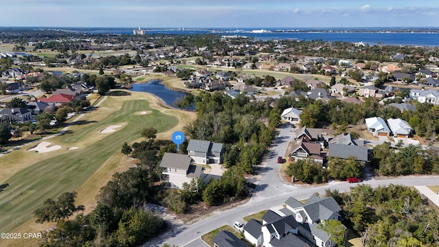 drone / aerial view with golf course view, a water view, and a residential view