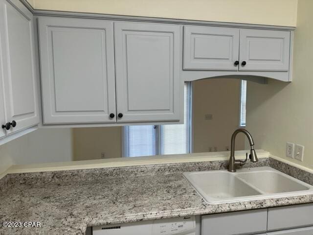 kitchen with sink, dishwasher, and white cabinets