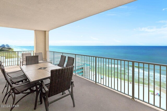 view of building exterior featuring a water view and a beach view