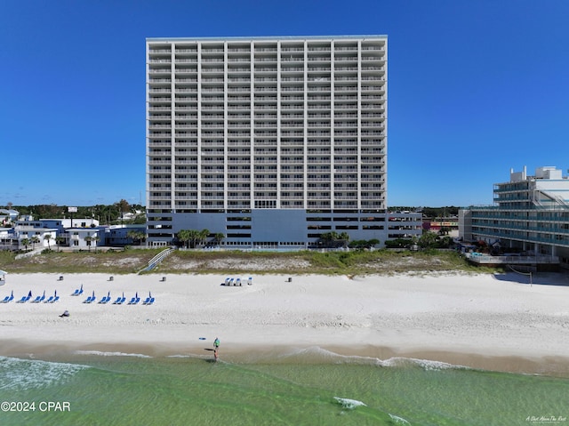 view of property with a water view and a beach view