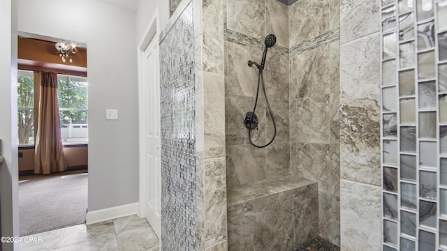 bathroom with an inviting chandelier and tiled shower