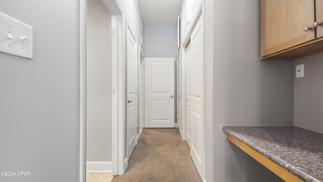 hall with light colored carpet