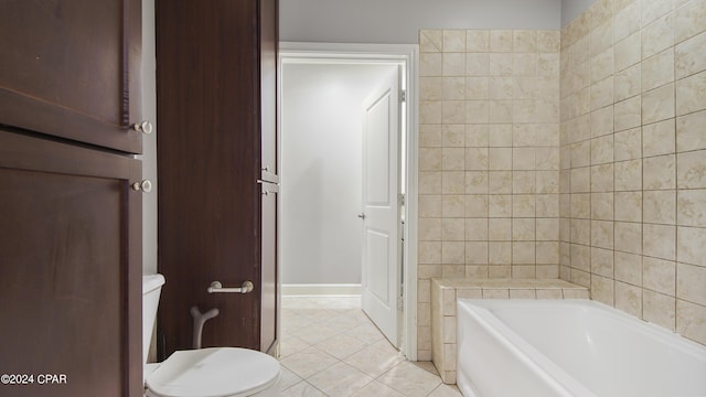 bathroom featuring tile patterned flooring, a washtub, and toilet