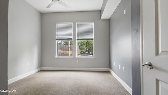 carpeted spare room featuring ceiling fan