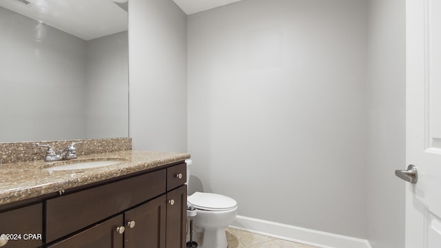 bathroom featuring tile patterned floors, vanity, and toilet