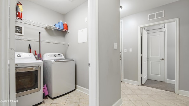 washroom with washing machine and dryer and light tile patterned flooring