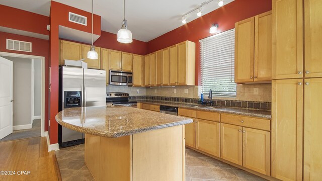 kitchen with pendant lighting, sink, decorative backsplash, a kitchen island, and stainless steel appliances